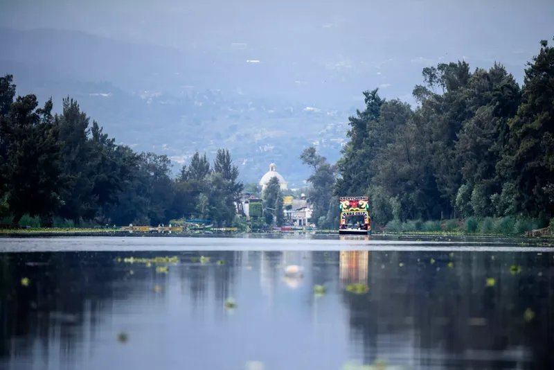una colorida embarcación se desliza por el río en Xochimilco