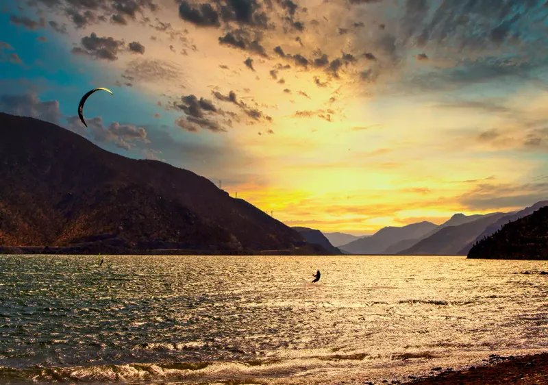 Persona haciendo parasailing con una hermosa puesta de sol de fondo