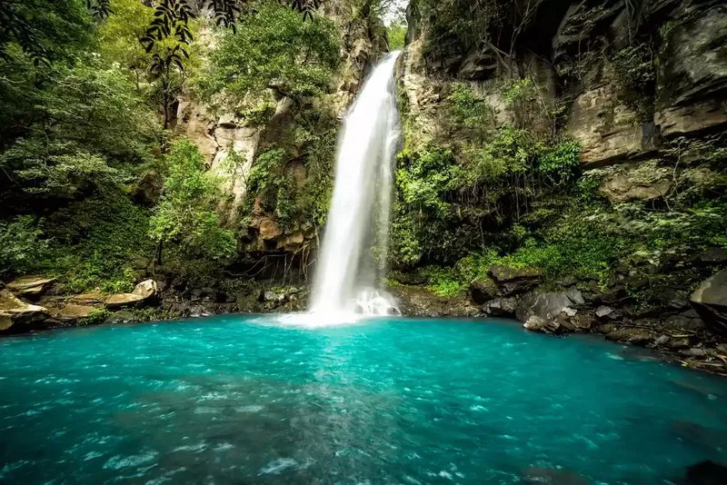 Lago azul con una cascada en el Parque Nacional Rincón de la Vieja