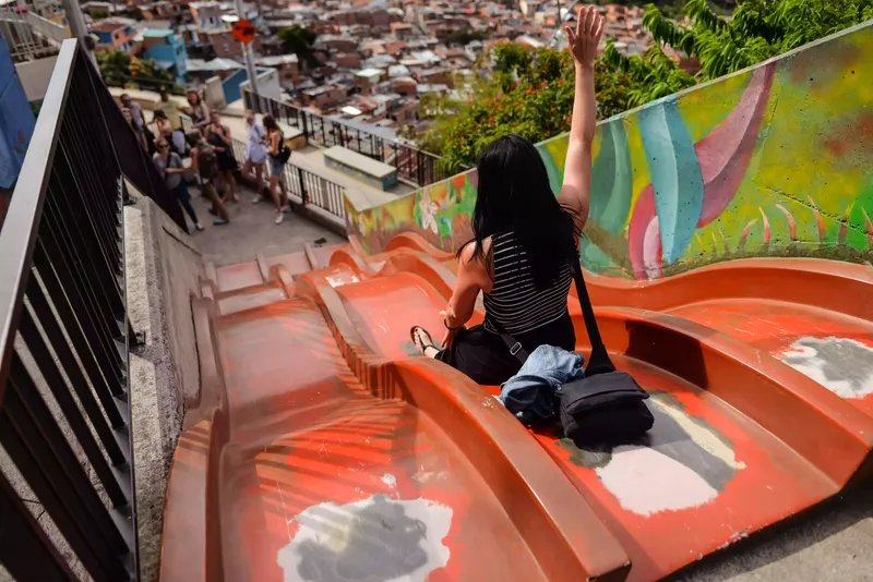 Turista estadounidense se desliza por un tobogán en la Comuna 13 de Medellín