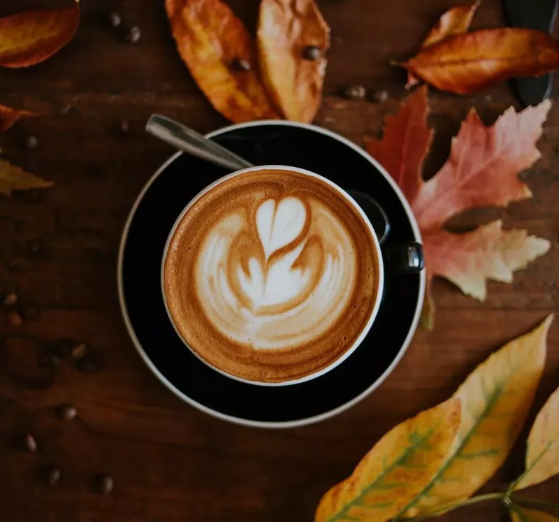 Arte del café con leche con hojas detrás